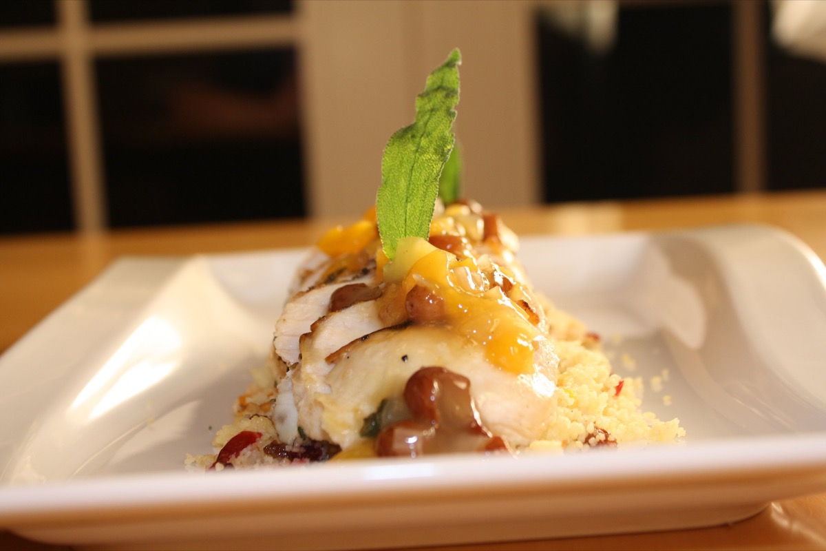 Stuffed chicken roulade with mango on couscous topped with sage