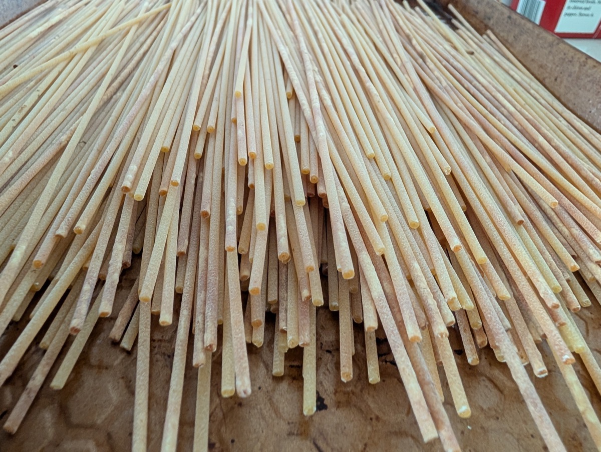 Freshly made spaghetti drying on a board